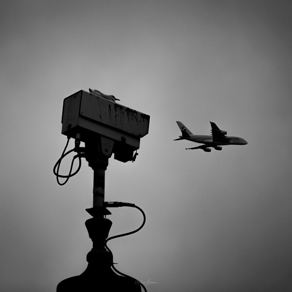 A telephoto lens of the Square's CCTV cameras and a passing plane