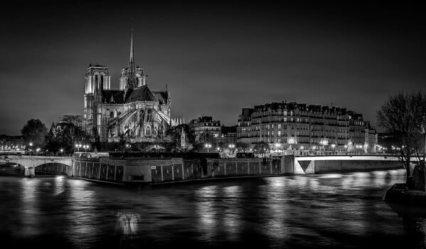 Cathedral Notre Dame of Paris and the Ile de la Cité seen from the Tournelle bridge at the night in B/W. On the Seine, you can also see the Pont St-Louis).