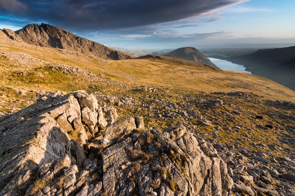 Stunning sunset side light hits the rocky foreground on Lingmell looking over towards Sca Fell and Wast Water.