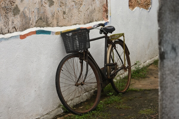 An old rusty bicycle against the 300 year old wall built with coral, lime, sand and honey