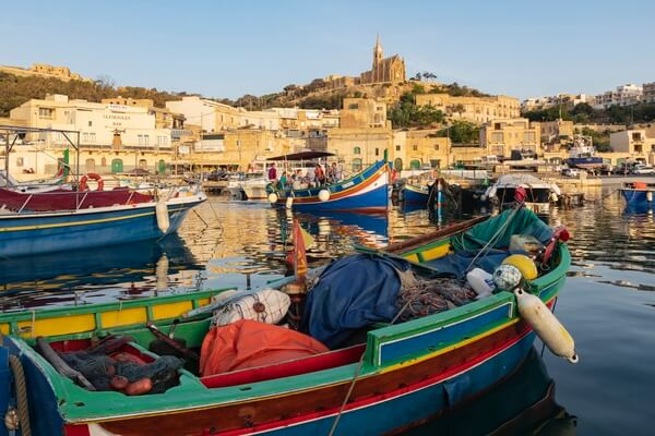 Colorful boats (luzzu) line the dock at Mgarr