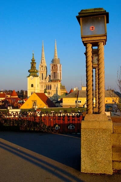 Sunny winter afternoon on Strossmayer promenade with view on three towers of cathedral and Virgin Mary church