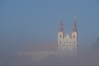 Church with two spires in foggy autumn morning