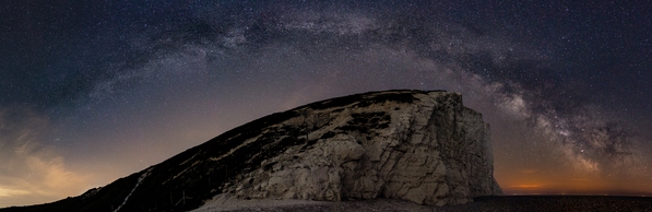 The Milky Way over the Seven Sisters. This is an eight photo panorama across 180°, hence the distortion of the shape of the cliffs.