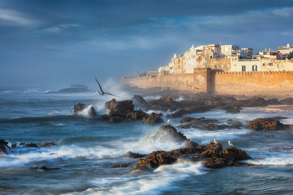 View of the Essaouira Ramparts during sunset. Photo spot is the wall close to the port. This view works best during incomming tide on a windy day.