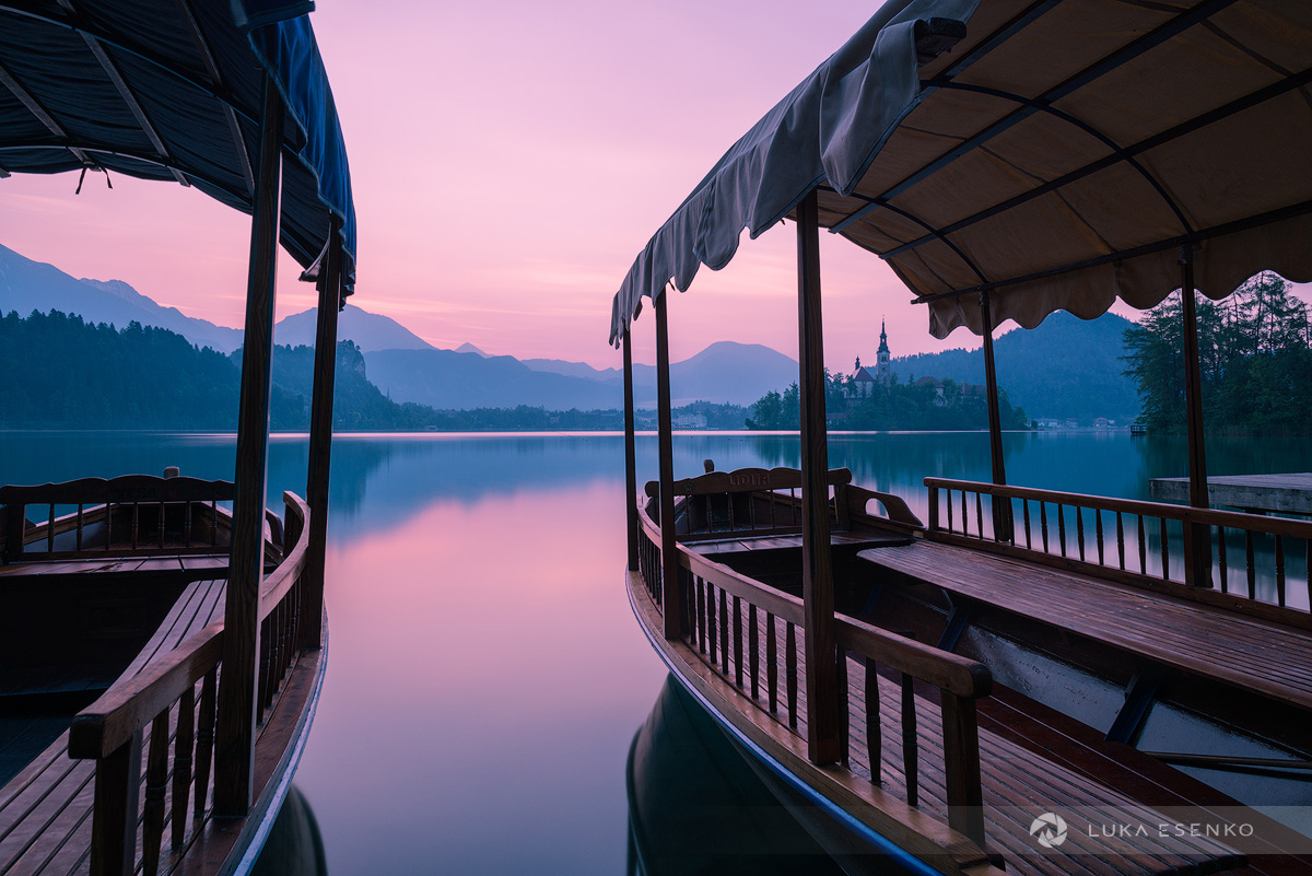 Sunrise at Lake Bled, framed by local Pletna boats
