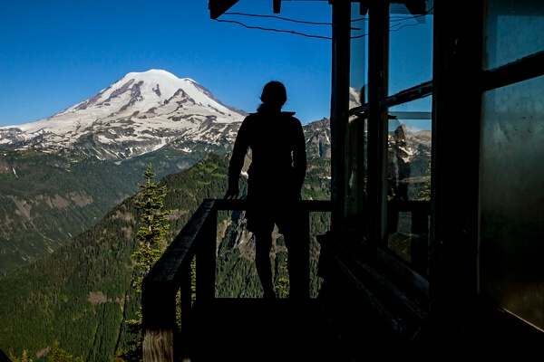 Hiker on outside balcony of Shriner Peak Fire Lookout