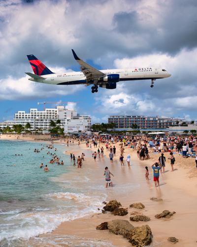 A large jet landing, viewed from the beach bar