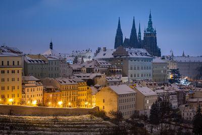 Winter view of Prague Castle with Uvoz street lit by lamps.