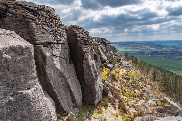 A beautiful gritstone climbing crag, high over the valley with Skipton in the distance.