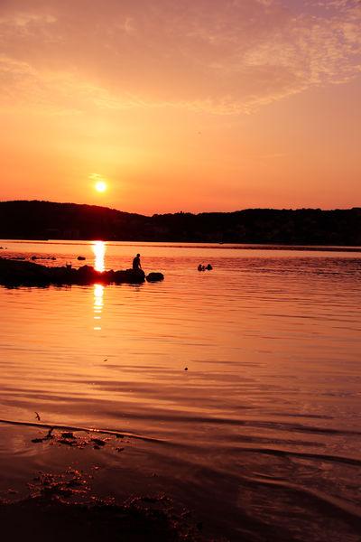 A fisherman enyoing the summer sunset
