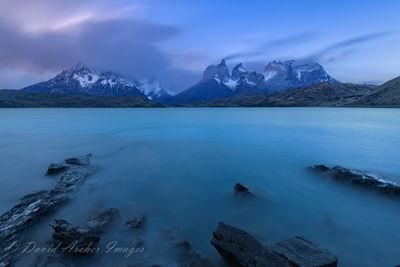 I just returned from Patagonia. We had planned to stay at the Hosteria Pehoe, but found that it had failed an inspection and was closed.  We had to find another place to stay and drive to get there, but the scenery is spectacular.  This was a very windy and cold evening blue hour on the island.