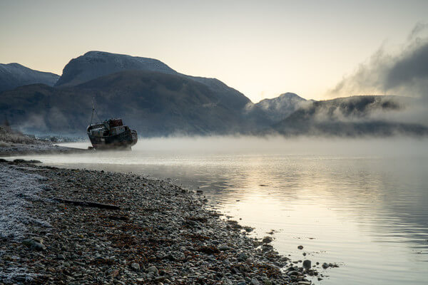 The boat with Ben Nevis behind on a cold and misty morning