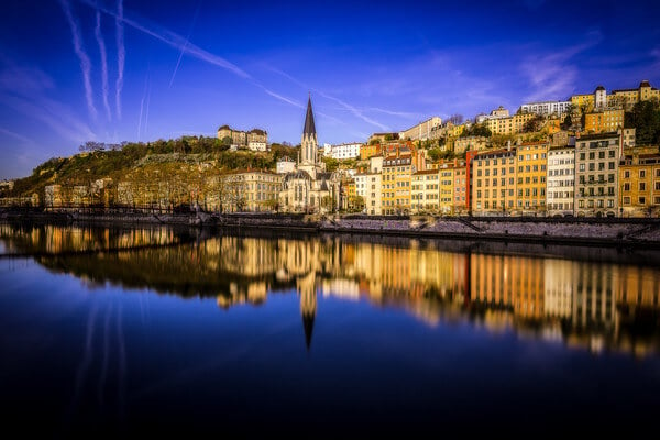 Blue Hour on the Saone in Lyon at the morning. 
You can see St-Just High School at the top of the Hill in the background, as well as the footbridge and the Church of St. George along the Saône.