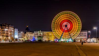 Big wheel on the Bellecour square at Lyon by night. The Bellecour square is the largest square in the city of Lyon (62,000 m2) and the fifth largest square in France. It is also the largest pedestrian square in Europe.
At its center is an equestrian statue of Louis XIV. Another statue, representing the Little Prince and Antoine de Saint-Exupéry, is located at the south-west end of the square.
There are two pavilions on the square and services of the Tourist Office, as well as a small children's park, a fountain, two breweries and periodically a ferris wheel (during the Christmas and New Year holidays).