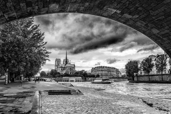 Cathedral Notre Dame of Paris and the Ile de la Cité seen from under the Tournelle bridge in B/W. 