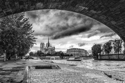 Cathedral Notre Dame of Paris and the Ile de la Cité seen from under the Tournelle bridge in B/W. 