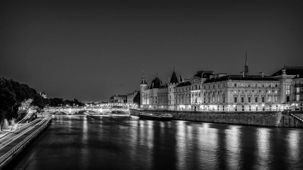 The Conciergerie and the Pont au Change at Paris in B/W view from the Pont Neuf, the old bridge of Paris. On the left, the lights are the cars on the Voie Georges Pompidou.