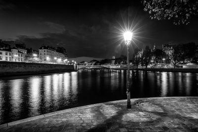 Start of night on the Square Louis Aragon at the end of Ile St-Louis in Paris in B/W. In the distance, you can see Pont d'Arcole on the Seine, the Paris City Hall, the city Theater, the Chatelet Theater and the Tour Saint-Jacques.