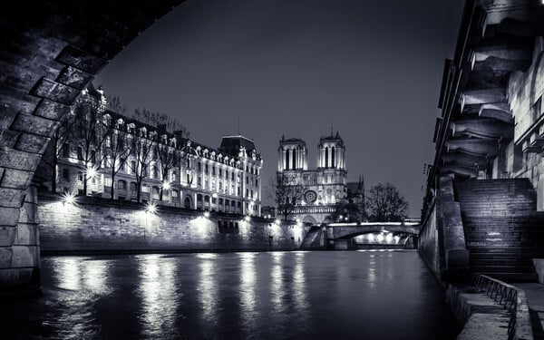 The Cathedral Notre Dame de Paris and the police headquarters by night in N/B seen from under the Pont St-Michel, Promenade René Capitan along the Seine. We also see the Petit Pont.