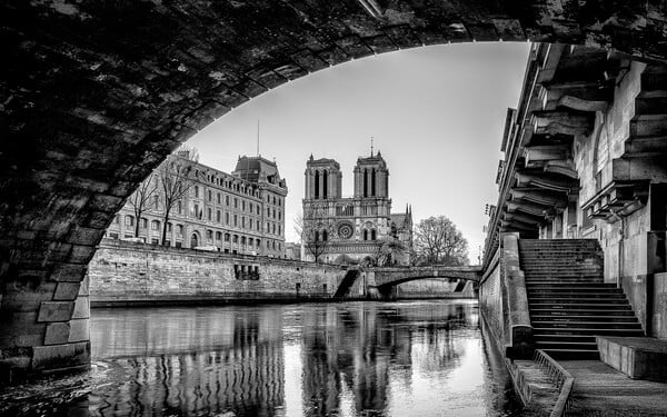 The Cathedral Notre Dame de Paris and the police headquarters in B/W seen from under the Pont St-Michel, Promenade René Capitan along the Seine. We also see the Petit Pont.