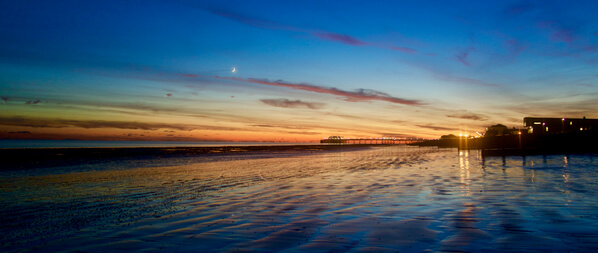 Taken one evening at sunset, looking west, the moon was perfectly positioned as a crescent above the pier