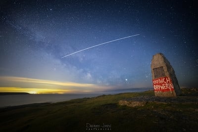 Taken near the Salt House, at the Port Eynon view point.  The graffiti was painted by an unknown person sin solidarity with the Welsh “Cofiwch Dryweryn” movement (though this homage has a spelling error).  Flying over head were the first passing of the Space X Starlink satellites.
