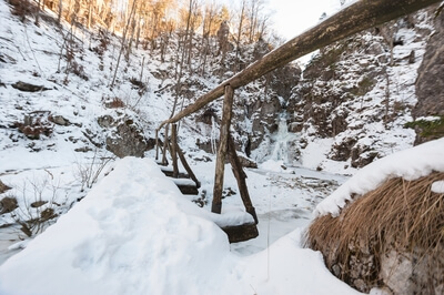 Bridge near waterfall in winter time