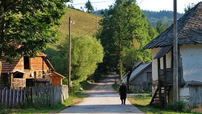 Milojko's wife walking down on one of the streets where the kids are not playing anymore. The village is slowly dying. 