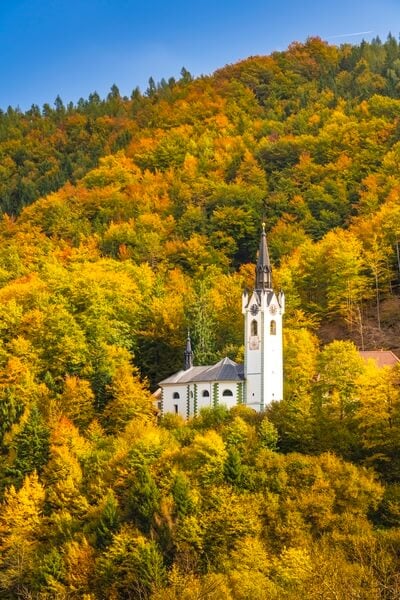 The Church of St. Mary  with fall foliage color above Kropa town.