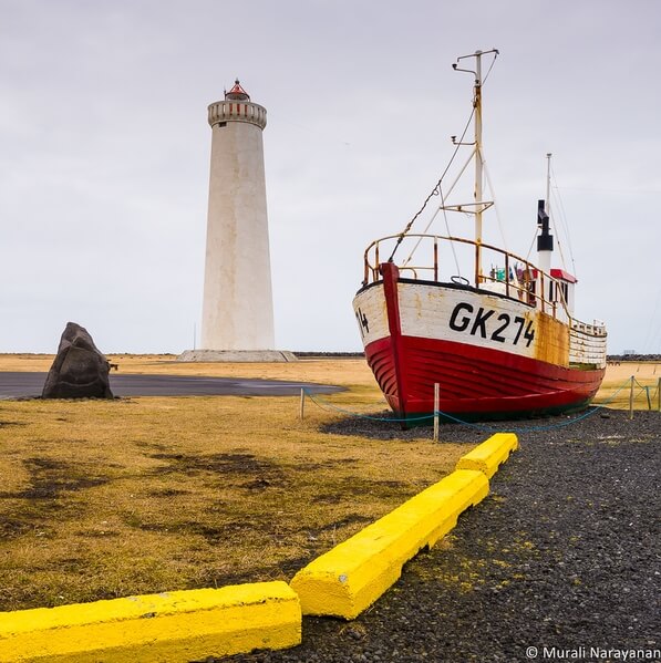 The newer Garður Lighthouse and a boat in front of it shot from the nearby museum