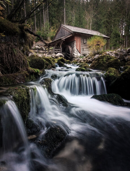 A wooden mill below the waterfall.