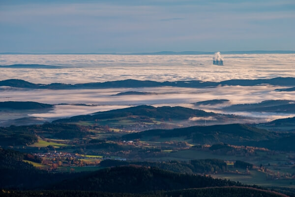 View from the Boubín lookout tower with the Temelín nuclear power plant floating above the fog.