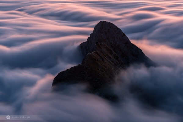 Mali draški vrh peaking out of clouds.