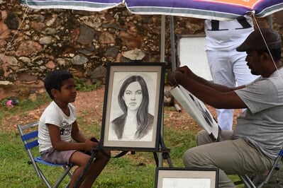 Sketching a portrait of a boy by a wayside artist in Galle Fort 