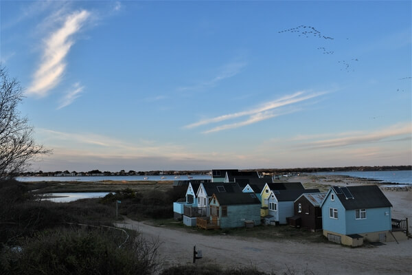 Birds flying over the huts in an arrowhead formation and the huts blended nicely