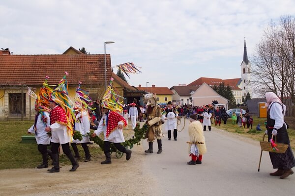 Carnival parade in Markovci: orači (ploughmen) with kurent and jajčarica going door to door through village
