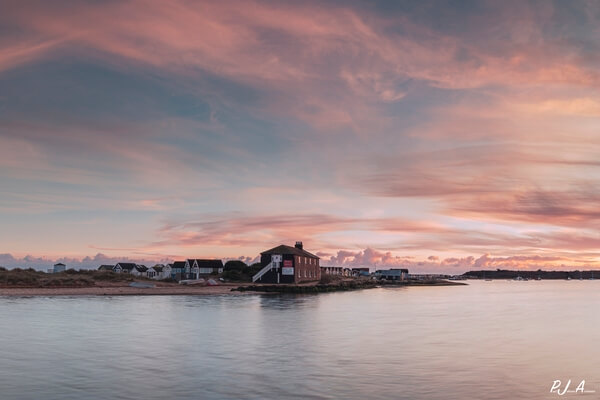 The setting sun reflected on the 'Black House' from Mudeford Quay