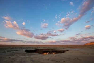 Clouds above the Darvaza crater are lit up at sunrise