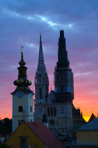 Strossmayer Promenade at dawn: view on three towers of cathedral and Virgin Mary church with colorful sky in the background