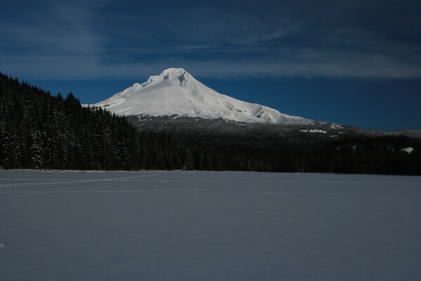 A similar view in winter. There is a sno-park on Highway 26, then you can ski or snowshoe along the road to the area near the dam for this photo. Trillium Lake is very popular in winter. On a nice weekend, the sno-park will be filled.