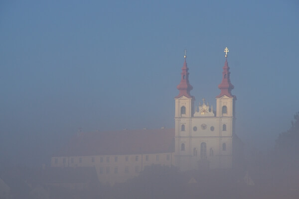 Church with two spires in foggy autumn morning