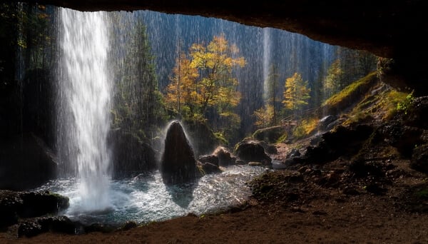 Standing behind the water curtain of the upper waterfall, the sudden apperance of the sun gave a nice backlite of the colorful autumn trees.