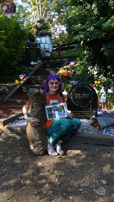 TAG Founder Fee Warner at Marc Bolan's Rock Shrine, Gipsy Lane, Barnes, SW15 5RG London. Photograph taken on the 16th September 2021 - The 44th Anniversary of his passing at this site. Marc's Shrine has been cared for since 1999 by TAG (T.Rex Action Group) via an in-perpetuity lease on the site. The PRS Memorial was installed in September 1997 for the 20th Anniversary. Five years later the bronze bust of Marc Bolan was installed for the 25th Anniversary. Both were unveiled by Marc Bolan's only heir Rolan Bolan who was just 10 days short of his second birthday when his dad died. That fateful night Rolan was asleep at his paternal grandparents home in Putney. Marc and his partner, Rolan's mother were on their way home at 142 Upper Richmond Road West, Sheen.  