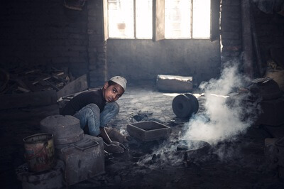 Young boy working in propeller foundry