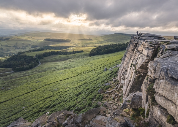 A windy, rainy and cloudy evening on Stanage Edge. A sunset did not look hopefull but on occasions patchy light broke through the clouds. Also capturing a lone person on the edge adding scale to the cliff edge.