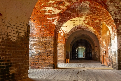 View of lower level of the southeast rampart. The semi-circles on the floor are traversing tracks for cannon. The cannon were fired through embrasures which are out of sight on the right side of the photograph.