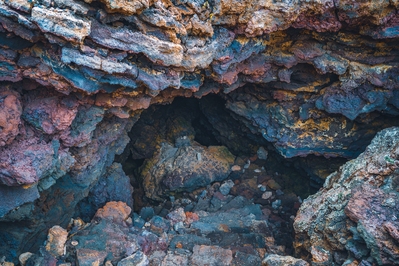 Peering down into a small lava cave