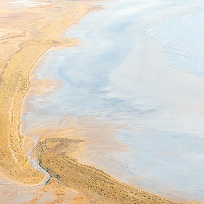 Aerial shot of sand dunes, low lying scrub and salt lake in the desert country of South Australia