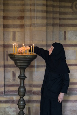 A nun cleaning up the candles